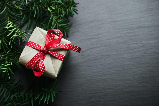 Christmas handmade presents with red ribbon on wooden background