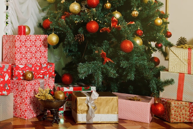 Christmas holiday background of boxes with happy new year gifts under decorated Christmas tree