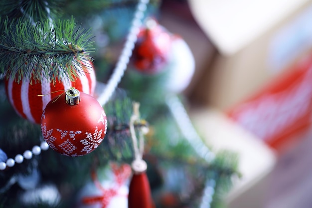 사진 크리스마스 휴일 배경입니다. 보케와 눈으로 장식된 나무에 매달려 있는 은색과 컬러 보블은 공간을 복사합니다.