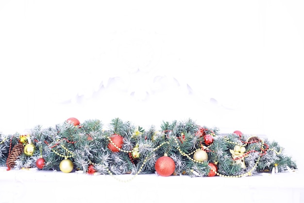 크리스마스 휴일 배경입니다. 보케와 눈으로 장식된 나무에 매달려 있는 은색과 컬러 보블은 공간을 복사합니다.