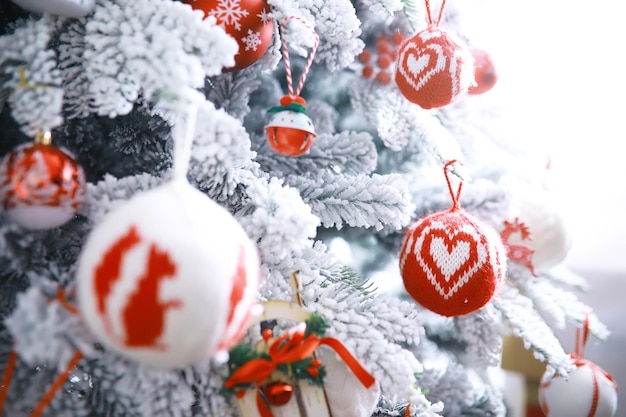크리스마스 휴일 배경입니다. 보케와 눈으로 장식된 나무에 매달려 있는 은색과 컬러 보블은 공간을 복사합니다.