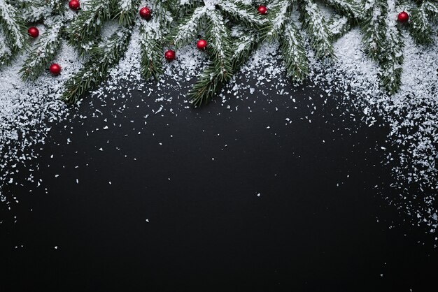 テキストのコピースペースとクリスマス休暇の背景。フラットレイ、上面図。雪の中でモミの枝とヒイラギの果実と新年の装飾