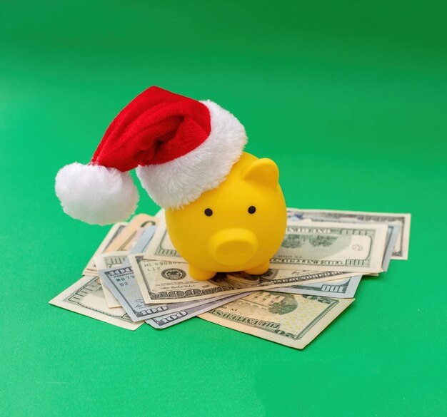 Christmas holiday bonus and expenses piggy bank with santa hat on us dollars money