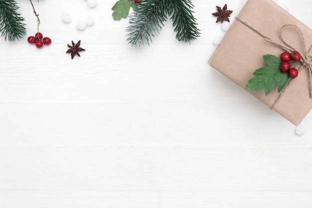 Christmas holiday composition of Christmas present and decor on a white wooden background, copy space, top view.