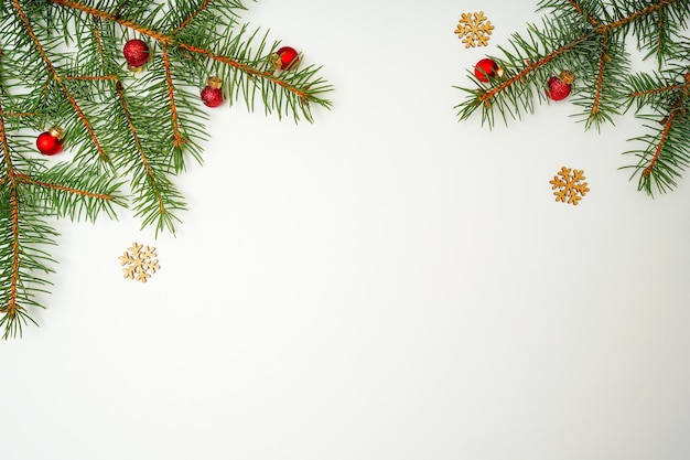 モミの枝の赤いボールと白い背景の上の木から雪の結晶クリスマス休日組成
