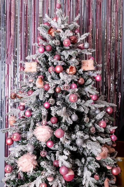 クリスマス休暇のモミの枝針葉樹の円錐形の銀ピンクの装飾品飾られたクリスマスツリーきらびやかな