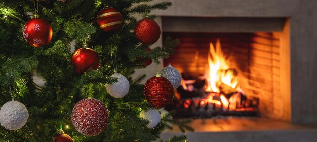 Christmas holiday home background warm cozy burning fireplace\
and xmas tree decoration