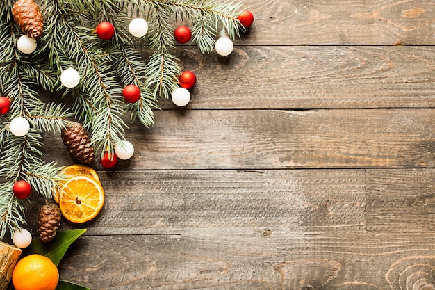 Christmas holiday surface with ornaments on rustic wooden surface.