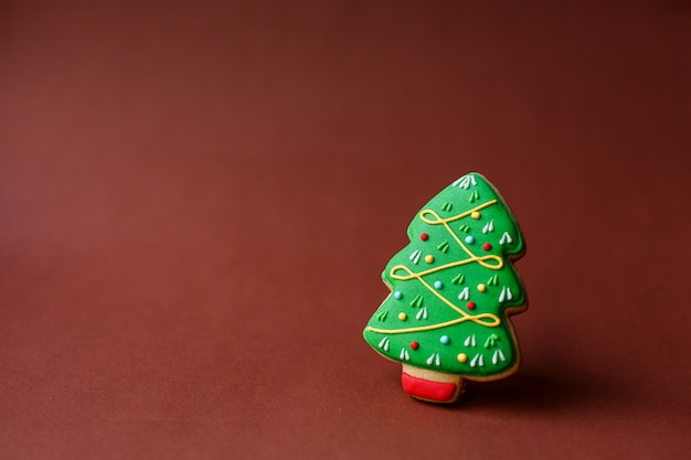 Christmas holiday sweets. Christmas holiday traditions. Christmas tree gingerbread on dark red