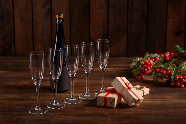 Christmas holiday table with glasses and a bottle and gifts