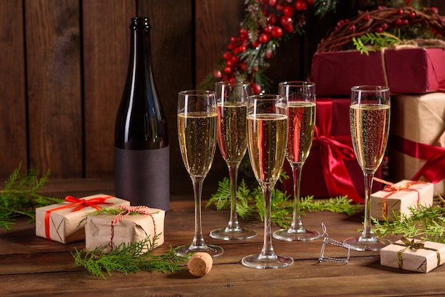 Christmas holiday table with glasses and a bottle and gifts