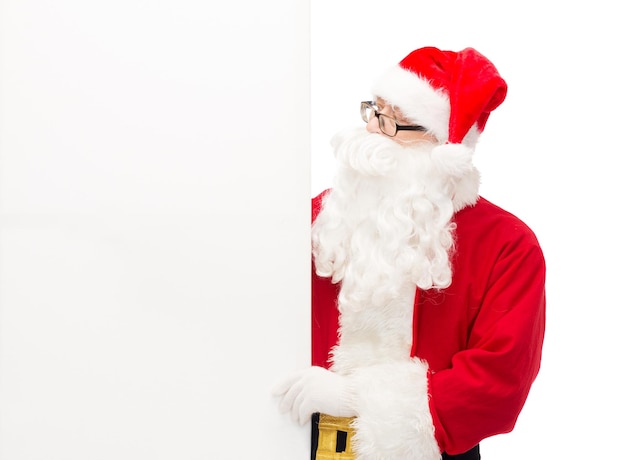 크리스마스, 휴일, 광고 및 사람 개념 - 흰색 빈 광고판이 있는 산타클로스 의상을 입은 남자