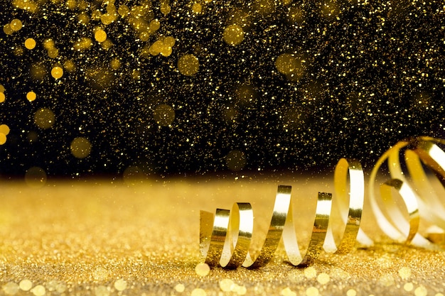 Foto sfondo vacanze natalizie - nastro dorato, glitter e effetto bokeh su sfondo nero, spazio copia
