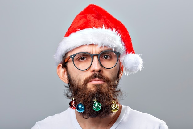 Christmas, holidays, barbershop and style concept - young handsome bearded santa claus man with many