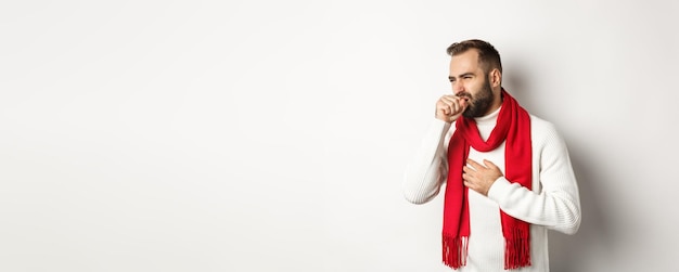 Foto vacanze di natale e concetto di celebrazione uomo che si sente male tosse e smorfie dal mal di gola