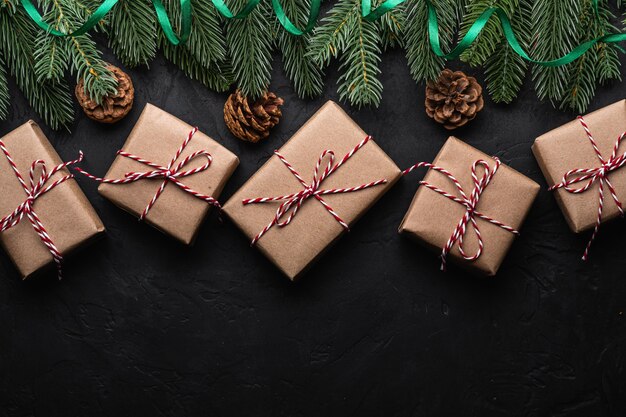 Christmas holidays composition. Green ribbon and giftbox wrapping, fir-tree, pine cones. Copy space