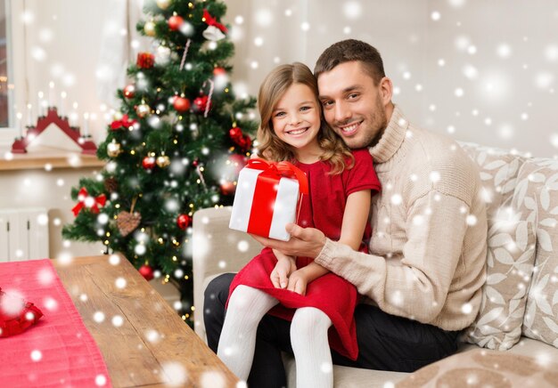 크리스마스, 휴일, 가족, 사람 개념 - 웃는 아버지와 딸이 선물 상자를 들고 집에서 포옹