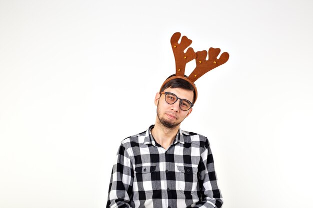 Christmas, holidays and funny concept - man with deer horns and rudolf nous on white space