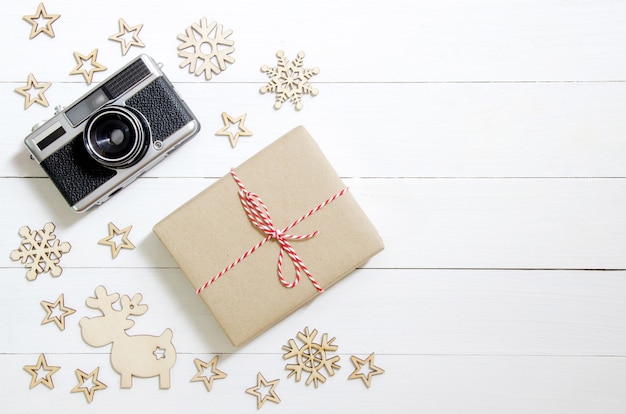 Christmas holidays and Happy New Year background. Gift boxes, camera and Christmas decoration on wooden table.