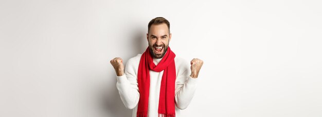 Foto vacanze di natale e concetto di nuovo anno uomo felice che celebra la vittoria vincendo e facendo pompe a pugno