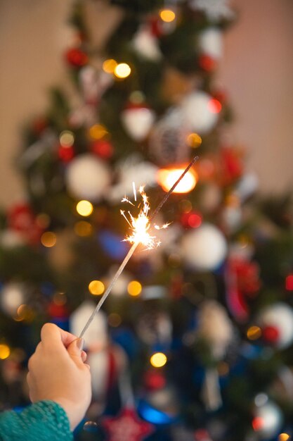 線香花火を持っているクリスマスの休日の女性の手