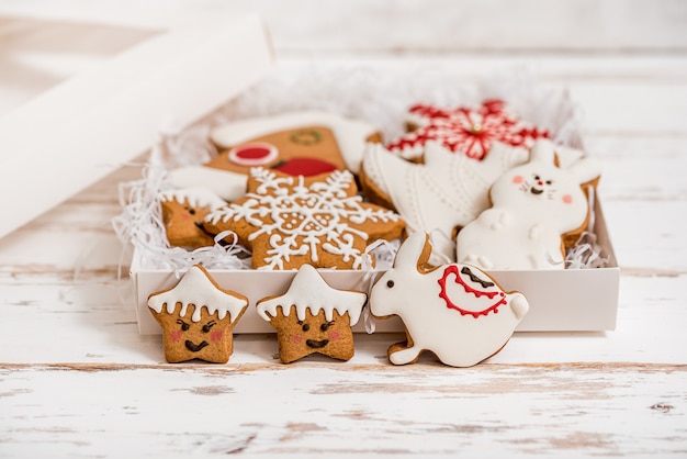 Biscotti di pan di zenzero fatti in casa di natale sulla tavola di legno. regalo di capodanno in scatola, sorpresa bianca