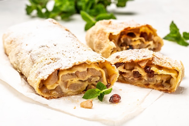 Christmas homemade pastry apple strudel pie with raisins\
cinnamon and powdered sugar close up