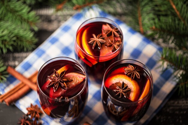 Christmas hot mulled wine in a glass with spices and citrus fruit. Mulled wine with cinnamon, anise and orange.