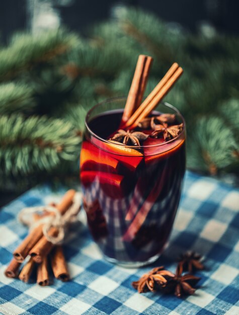 Christmas hot mulled wine in a glass with spices and citrus fruit. Mulled wine with cinnamon, anise and orange.