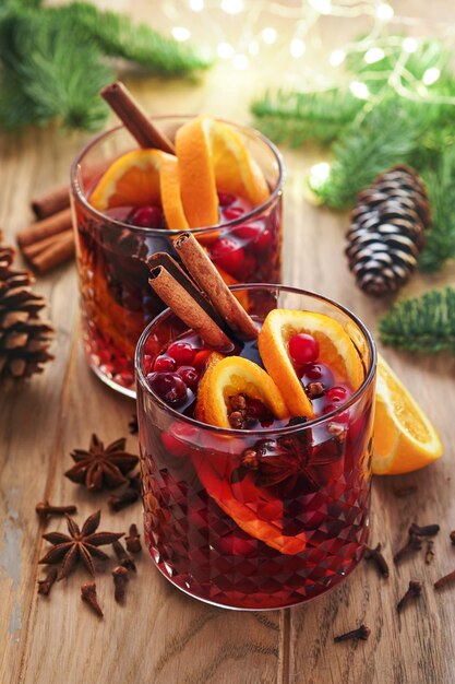 Christmas hot mulled wine glasses of mulled wine with aromatic\
spices cinnamon anise sugar and fir tree branches with bokeh and\
decorations traditional xmas festive drink winter christmas\
drink