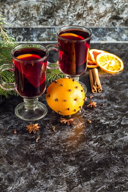 Photo christmas hot mulled wine with cinnamon orange and anise on dark background with tree