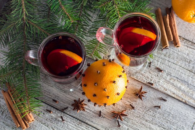 Christmas hot mulled wine with cinnamon orange and anise on white wooden surface