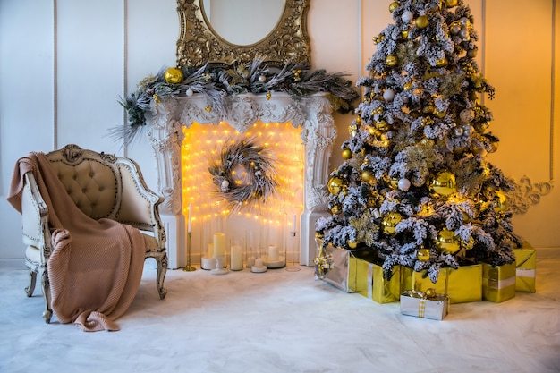 Christmas interior with artificial fireplace and New Year Tree decorated for holiday