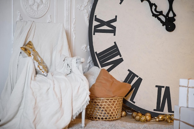 Christmas interior with big clock armchair and white plaid\
closeup interior photo studio