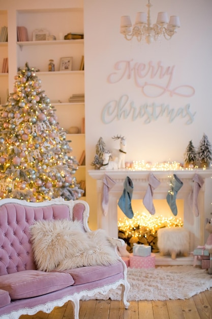 Рождественский интерьер с камином, розовым диваном, елкой и розово-голубыми украшениями