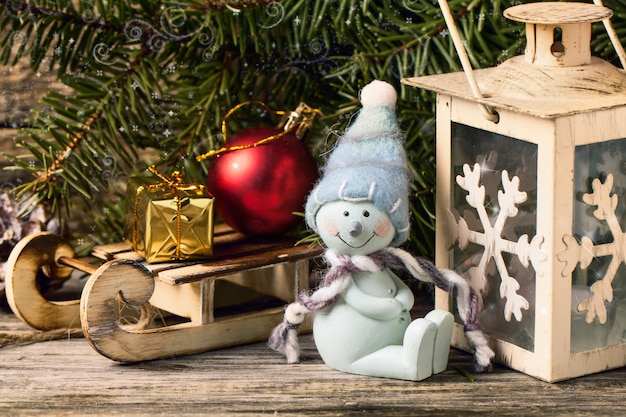 Lanterna di natale con l'albero di natale e il pupazzo di neve