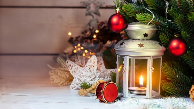 Christmas lantern with snowfall hanging on a fir branch