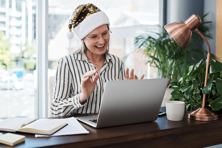 Photo christmas laptop and video call with business woman in office for virtual meeting or webinar computer internet and management with mature employee in workplace for online meeting or training