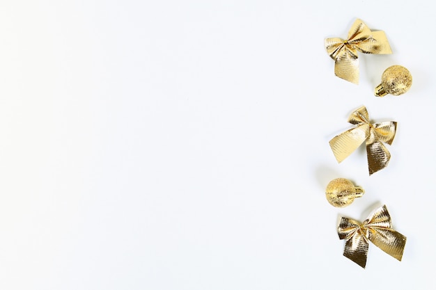 Рождественский макет. Золотой игрушечный мяч, лук на белом фоне. Новый год 2019, рождество, зимняя концепция