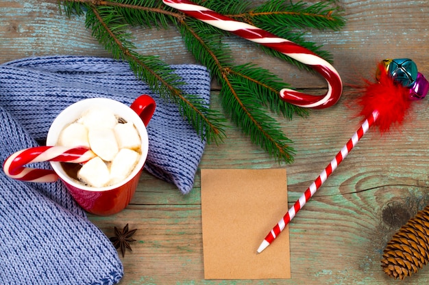 Christmas letter writing on paper on wooden background with decorations.