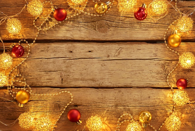 Christmas lights and balls on a wooden background with copy space