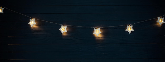 Christmas lights on blue wooden background