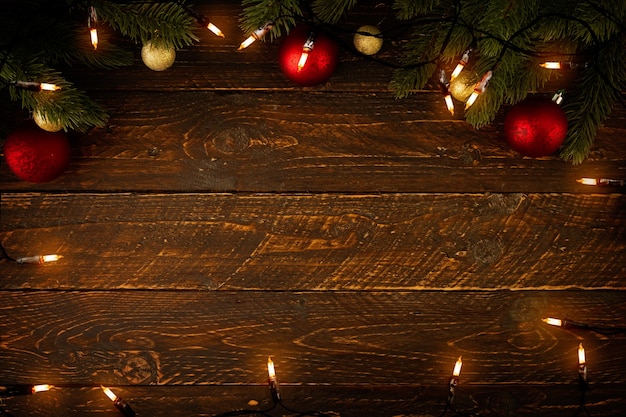 写真 クリスマスライト電球と松の葉の装飾を木の板に