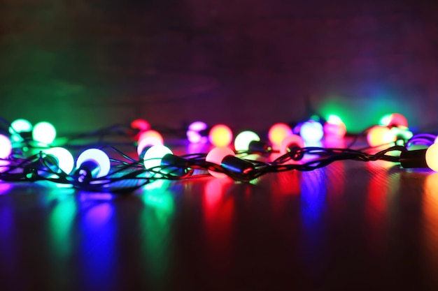 Christmas lights glowing on wooden background