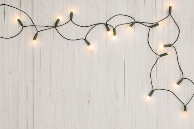 写真 白い木製の背景にクリスマスライト
