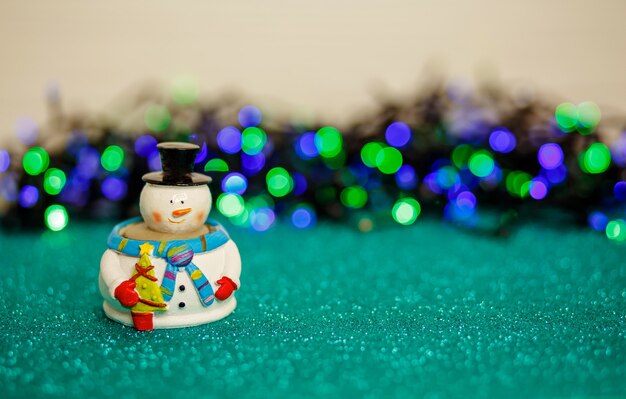 Christmas lights and snowman over abstract lights merry christmas