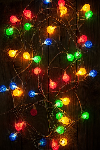 Christmas lights on wooden background. Christmas decorations.