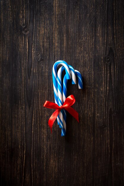 Christmas lollipops on a dark wooden background, top view