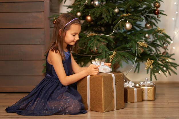 Christmas magic fairy tale. Little girl dreams before opening Santa's present for Christmas