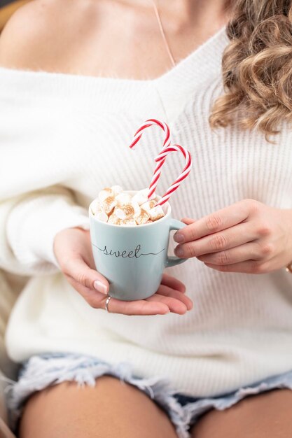 Christmas magic scene cozy atmosphere xAWoman holding cup of drink with marshmallows